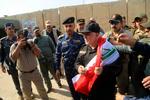 Iraks premierminister, Haida al-Abadi, holdt det irakiske flag ved sin ankomst til Mosul søndag, hvor han erklærede byen tilbageerobret fra IS. Med hjælp fra den USA-ledede koalition indledte den irakiske hær tilbageerobringen af byen i oktober 2016. 