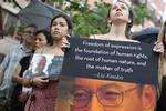 Demonstranter i New York holder torsdag efter meddelelsen om Liu Xiaobos død plakater med billeder af ham og hans kone. 