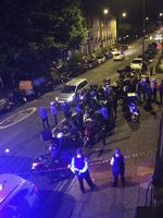 Politiet i London er samlet ved gerningsstedet efter et angreb torsdag, hvor en 32-årig mand fik kastet en skadelig substans i ansigtet af gerningsmænd, der stjal hans knallert - og kørte væk. Foto: Sarah Cobbold via AP 