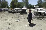 Antallet af civile dræbte i Afghanistan har været skyhøjt i første halvdel af 2017. Her går en dreng forbi ødelagte biler ved et gerningssted for et selvmordsangreb i den østlige Khost provins i maj.  