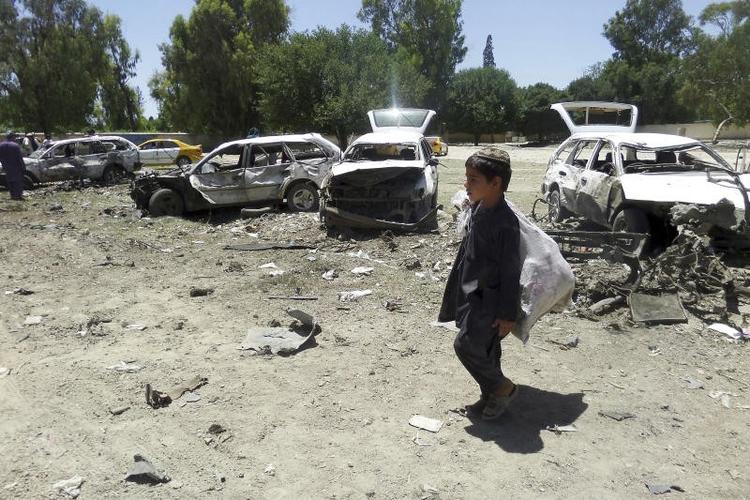 Antallet af civile dræbte i Afghanistan har været skyhøjt i første halvdel af 2017. Her går en dreng forbi ødelagte biler ved et gerningssted for et selvmordsangreb i den østlige Khost provins i maj.  