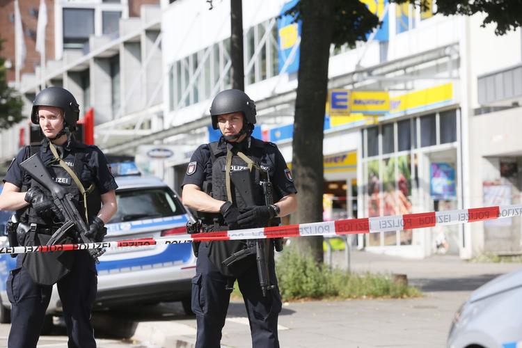 Politifolk sikrer området ved supermarkedet i Hamburg. En døde ved knivangrebet, mens flere er såret, melder politiet i byen. 