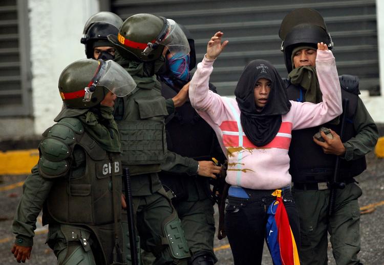 Situationen er meget anspændt i Venezuela. Her bliver en person undersøgt af politiet ved en demonstration i fredags i hovedstaden Caracas. 