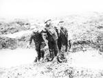 En tysk og en canadisk soldat hjælper hinanden gennem mudderet efter at være blevet såret under slaget om Passchendaele. 