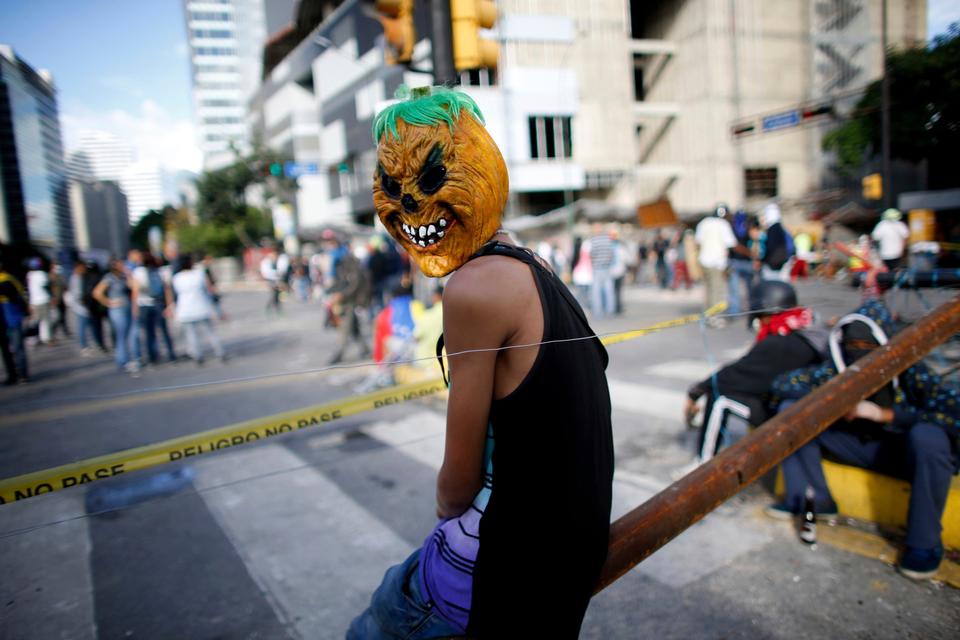 Flere af demonstranterne bærer masker. Her hviler demonstranter bag en af deres mange barrikader på valgdagen. 

Mange tomme valgsteder søndag peger på, at mange valgte en stille protest, ved at blive væk fra stemmeurnerne.  