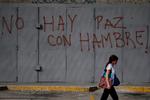 Venezuela er i forvejen i økonomisk krise, og befolkningen mangler både mad og medicin.  Her går en fodgænger forbi en væg, der er spraymalet med ordene »Der er ingen fred, når der er sult«.
Det er ikke muligt, at vide, præcis hvordan landets økonomi ser ud, da regeringen ikke vil offentliggøre nøgletal.  