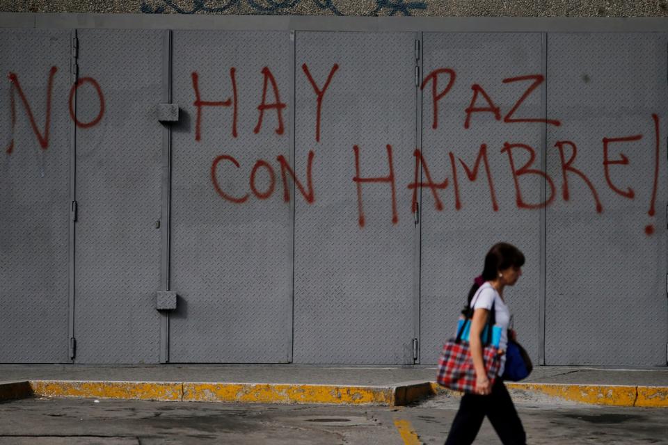 Venezuela er i forvejen i økonomisk krise, og befolkningen mangler både mad og medicin.  Her går en fodgænger forbi en væg, der er spraymalet med ordene »Der er ingen fred, når der er sult«.
Det er ikke muligt, at vide, præcis hvordan landets økonomi ser ud, da regeringen ikke vil offentliggøre nøgletal.  