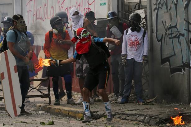 Afstemningen foregik søndag under blodige kampe mellem demonstranter og regeringsstyrker. Flere steder i Venezuelas hovedstad, Caracas, kastede demonstranter molotovcocktails mod politiet, lige som ved protesterne på dette billede fra d. 22. juli.  