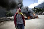 En demonstrant vandrer rundt i hovedstaden Caracas, mens motorcykler brænder. Betjente blev set kaste motorcykler på bålet, efter en eksplosion, hvor politiets motorcykler brændte. 