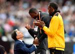 IAAF's præsident Sebastian Coe overrækker Justin Gatlin VM-guldmedaljen, mens Usain Bolt klapper anerkendende af sin overmand.
   