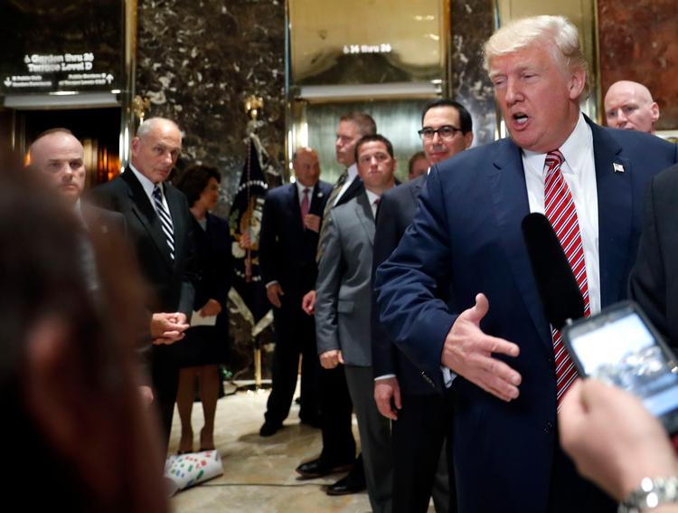 Trump kommenterer urolighederne i Charlottesville over for journlalister i sit Trump Tower i New York, mens stabschefen i Det Hvide Hus, John Kelly, (tv.) ser til.  