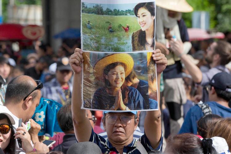 Tilhængere af Thailands tidligere premierminister Yingluck Shinawatra holdt hendes billede op foran Højesteret fredag, hvor Shinawatra skulle være mødt op i retten.  