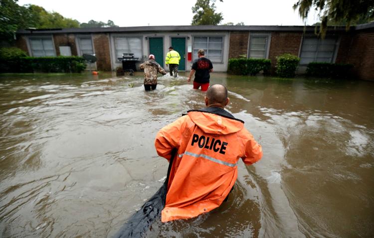 
Frivillige hjælper politiet i Texas med at undersøge endnu et oversvømmet hus i byen Dickinson, der er hårdt ramt af den tropiske storm Harvey. Foto: AP
   