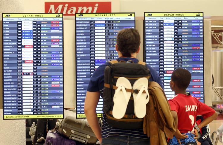 Passagerer tjekker afgange i afgangshallen i Miami International Airport torsdag. 
   