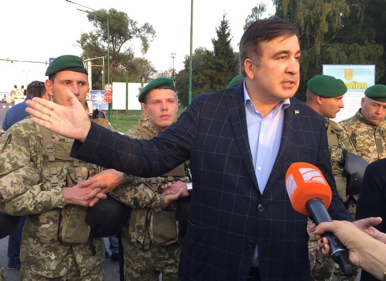 Mikheil Saakasjvili talte med journalister ved den polsk-ukrainske grænse, før han af sine tilhængere blev båret gennem kæden af ukrainske grænsevagter.
   