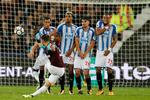 Huddersfields Mathias 'Zanka' Jørgensen (th.) ser ikke ud til at nyde denne situation på London Stadium mandag aften, hvor West Hams Aaron Cresswell hamrer et frispark mod mål. Bolden strøg dog forbi mål.
    
   