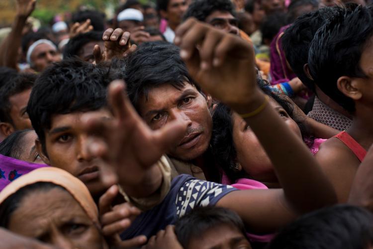 Myanmars minoritetsflygtninge rækker ud efter mad. 