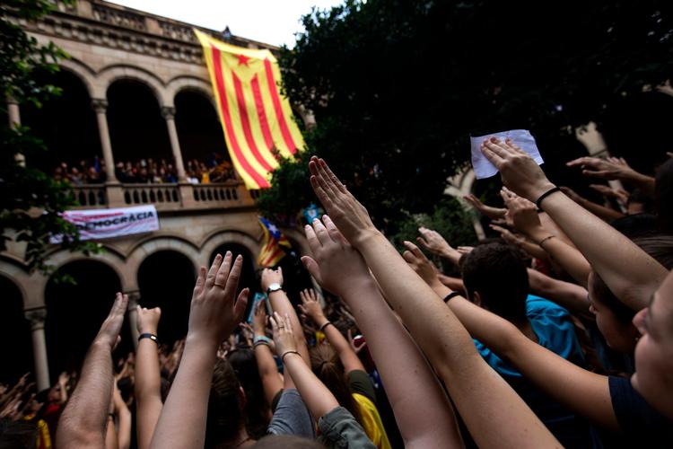 Massevis af studenter besatte fredag en af Barcelonas største universiteter, mens de symbolsk rakte deres hånd op i vejret og råbte slogans for selvstændighedsafstemningen. Foto: Emilio Morenatti