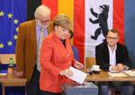 Iført sorte bukser og en karakteristisk rød blazer puttede Angela Merkel sin stemmeseddel i boksen, men hun sagde ikke noget til de fremmødte journalister. 