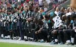 Før en kamp mod Baltimore Ravens i London i dag stod spillere og holdets ejer arm i arm eller knælede.  