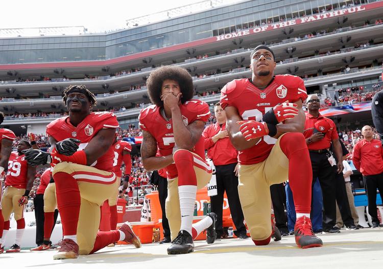 Eli Harold, Colin Kaepernick og Eric Reid fra San Francisco 49ers knæler, mens nationalhymnen bliver spillet inden en NFL-kamp med Dallas Cowboys. ARKIVFOTO. 