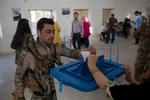 En kurdisk sikkerhedsvagt stemmer til uafhængighedsafstemningen i Irak. 