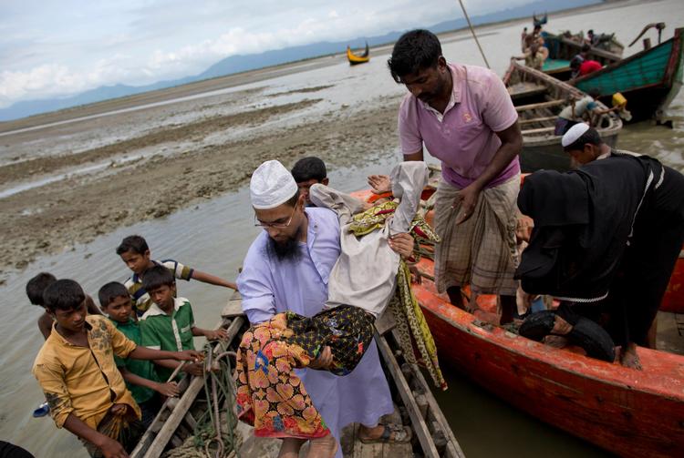 En frivillig fra Bangladesh hjælper rohingya-flygtninge i land. Flere end 500.000 er flygtet fra urolighederne i Myanmar siden august. (AP Photo/Gemunu Amarasinghe)
   