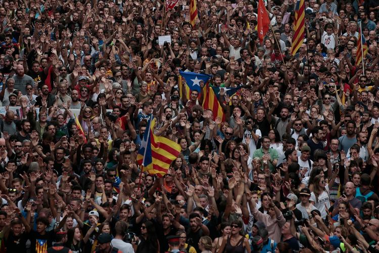 Demonstranter foran det nationale politis hovedkvarter i Barcelona i dag.  