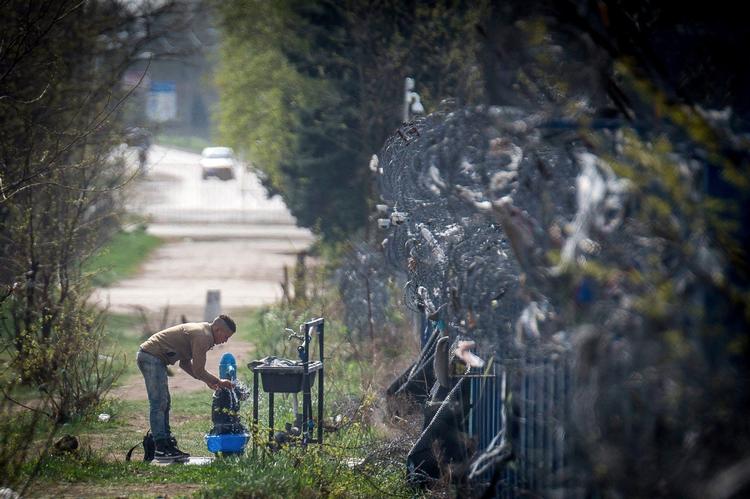 En flygtning vasker hænder på grænsen mellem Serbien og Ungarn, der er strengt bevogtet af det ungarnske grænsepoliti. (arkivfoto) 
