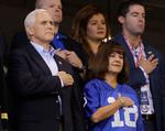 Vicepræsident Mike Pence og hans hustru, Karen, rejser sig med hånden på hjertet under nationalsangen. Kort efter udvandrede han, da ti spillere knælede. 