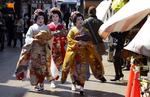 Japanske geishaer i traditionelle gevandter går nær templet Sensoji, som er en af Tokyos største turistattraktioner.  