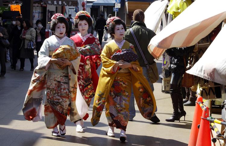 Japanske geishaer i traditionelle gevandter går nær templet Sensoji, som er en af Tokyos største turistattraktioner.  