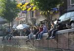 Turister og lokale slapper af ved kanalen i Amsterdams centrum. Mens nogle lokale er trætte af turisterne, har de besøgende generelt set et rigtig godt indtryk af Amsterdam og dets indbyggere. 