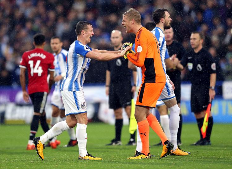 Huddersfiels Jonathan Hogg fejrer sejren over Manchester United med den danske målmand Jonas Lössl.  