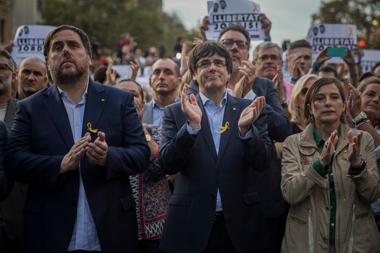 Der er krise i Spanien, efter at lederen af regionen Catalonien, Carles Puigdemont (i midten), har truet med løsrivelse.  