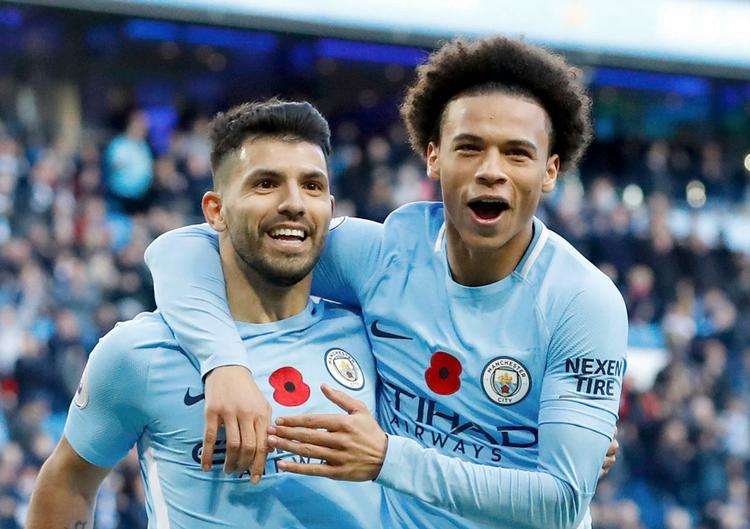 Sergio Agüero (tv.) fejrer sin scoring mod Arsenal sammen med Leroy Sane. 