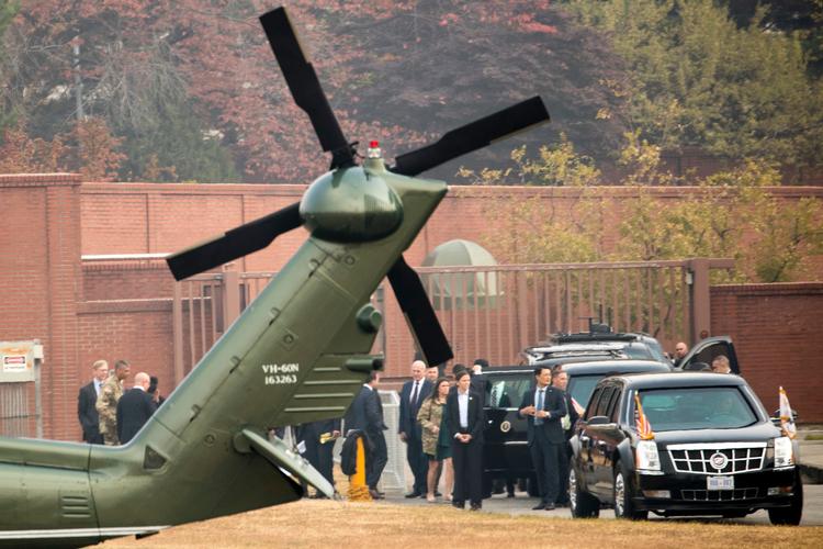 Præsident Donald Trump venter med sit følge ved den helikopter, der skulle have fløjet ham til den demilitariserede zone. 