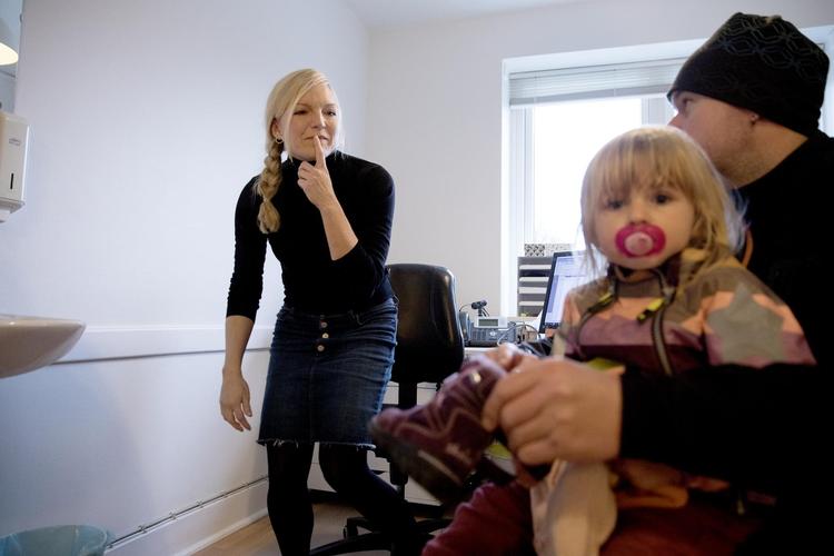 Liva ser nysgerrigt på fotografen, mens hendes far Michael Christensen diskuterer hendes velbefindende med læge Nina Åstrup. 
