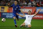 Grækenlands Sokratis Papastathopoulos (th.) slår ud med armene i afmagt, mens Kroatiens Nikola Kalinic jagter bolden under søndagens kamp i Piræus.
   