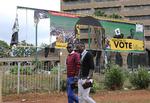 Indbyggere i Zimbabwes hovestad, Harare, passerer det regerende parti med ødelagte bannere af landets præsident.  