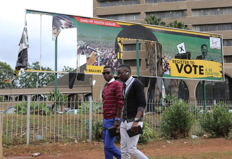 Indbyggere i Zimbabwes hovestad, Harare, passerer det regerende parti med ødelagte bannere af landets præsident.  
