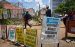 Fodgængere passerer nyhedsskilte i Zimbabwes hovedstad, Harare. Landets mangeårige præsident Robert Mugabe står efter alt at dømme over for en rigsretssag, da han ikke frivilligt vil træde tilbage.   
