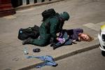 En ambulanceredder iført sikkerhedsudstyr som politiet forsøger at hjælpe en såret under en terrorøvelse ved en undergrundsstation i London.  