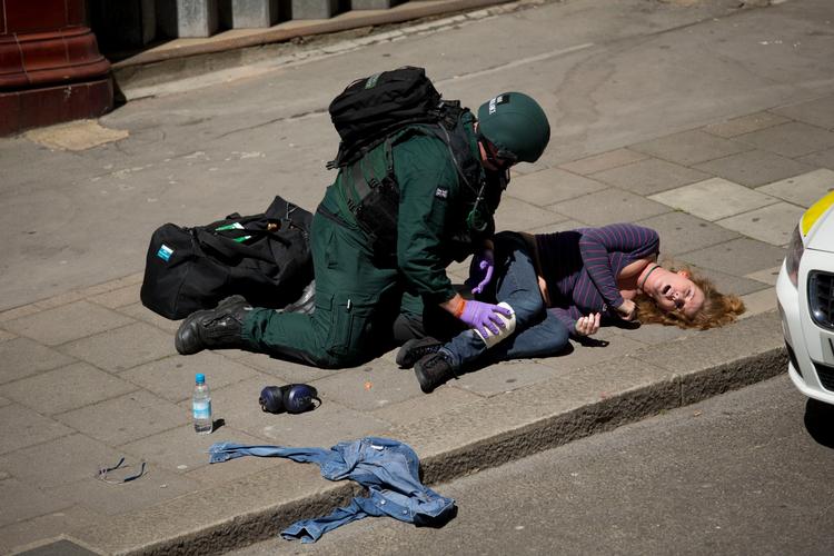 En ambulanceredder iført sikkerhedsudstyr som politiet forsøger at hjælpe en såret under en terrorøvelse ved en undergrundsstation i London.  