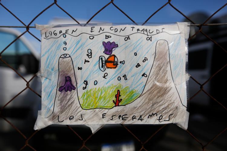 Et barn har hængt en tegning op på hegnet ind til flådebasen Mar del Plata - 'Find dem - vi venter på dem', står der.  