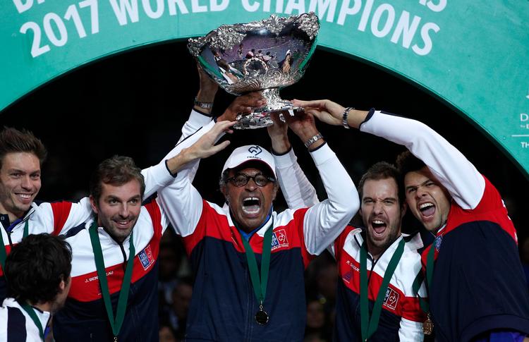 Som spiller tabte Yannick Noah (i midten) Davis Cup-finalen i 1982, men som fransk kaptajn har han vundet trofæet i 1991, 1996 og 2017. 
    French captain Yannick Noah, center, holds the cup after France won the Davis Cup at the Pierre Mauroy stadium in Lille, northern France, Sunday, Nov.26, 2017. France won the Davis Cup for the first time in 16 years after beating Belgium 3-2. (AP Photo/Christophe Ena)
   