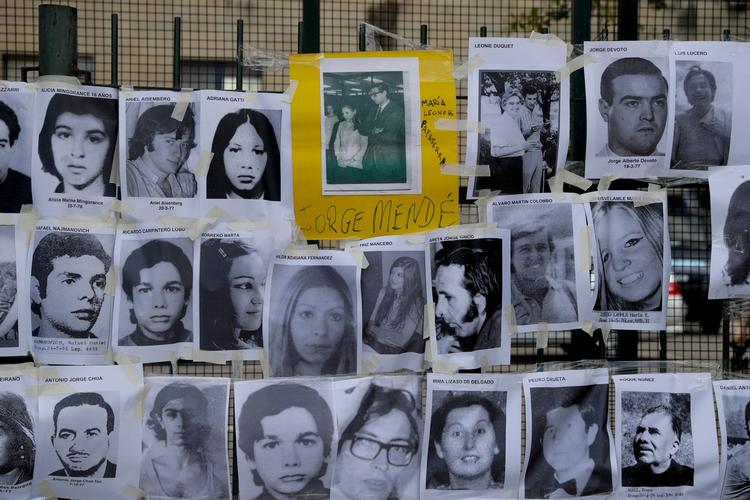 Billeder af nogle af de mennesker, der blev dræbt under den beskidte krig fra 1976 til 1983 var blevet hængt op på et hegn uden for retten i Buenos Aires, Argentina.  