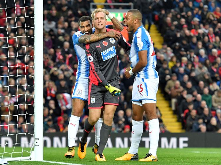 Der er glæde i Huddersfield hos Jonas Lössl (i midten) og Mathias 'Zanka' Jørgensen (th.). Dels over et reddet straffespark mod Liverpool tidligere på sæsonen, dels over udsigten til at skulle spille mod en klubkammerat ved VM-slutrunden. 
