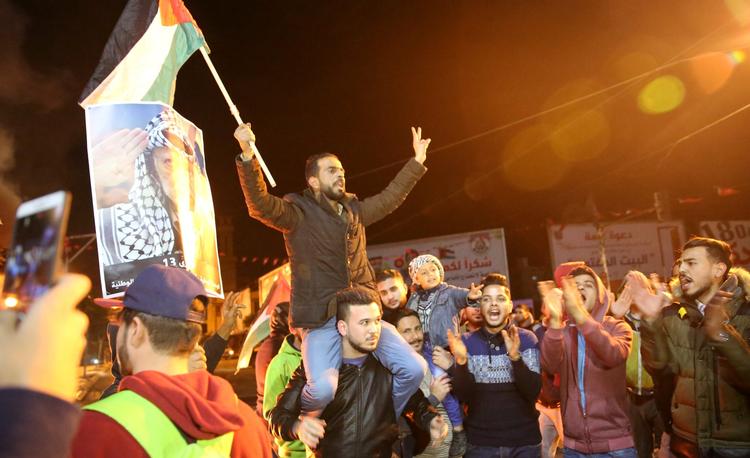 Palæstinensiske demonstranter råber og viser nationalflaget i Gaza i protest mod USA's beslutning om at rykke ambassaden til Jerusalem - og dermed anerkende byen som Israels hovedstad. 