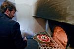 Den italienske kulturminister fejrer udnævnelsen af pizza som kulturarv ved at bage en pizza i verdens angiveligt første pizzaovn i Napoli. Foto: Ciro Fusco/ANSA Via AP
   